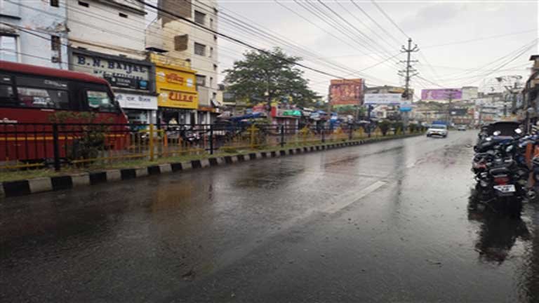 पश्चिम बंगाल में भारी बारिश और मेघगर्जन के बीच आसमान में छाए घने काले बादल और छाता लेकर चलते लोग