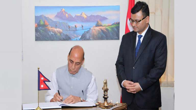 नई दिल्ली में नेपाली दूतावास पहुंचकर शोक पुस्तिका में संदेश लिखते रक्षा मंत्री राजनाथ सिंह, साथ में नेपाल बाढ़ राहत और भारत-नेपाल संबंध की झलक।