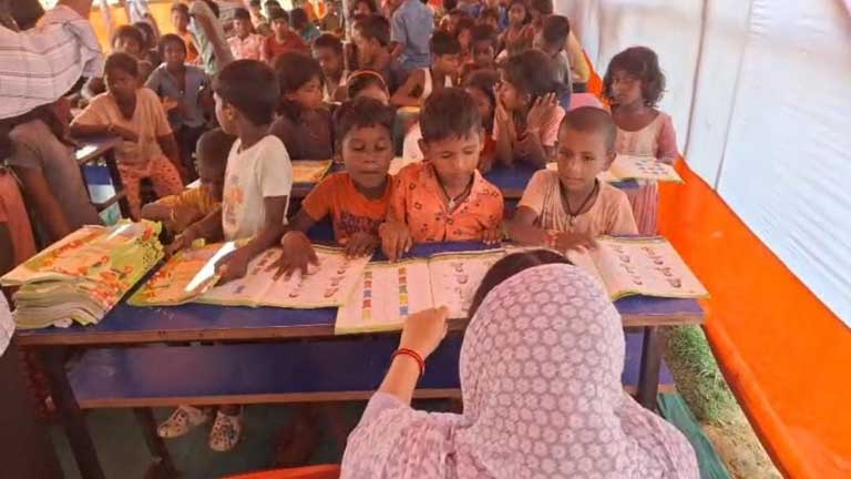 भागलपुर के पॉलिटेक्निक कॉलेज राहत शिविर में बाढ़ प्रभावित बच्चों के लिए बने अस्थायी स्कूल में पढ़ाई करते बच्चे और शिक्षक।